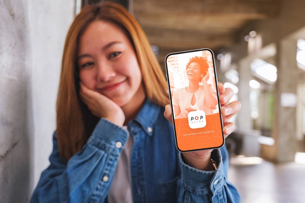 Mockup image of a beautiful young woman showing a mobile phone w